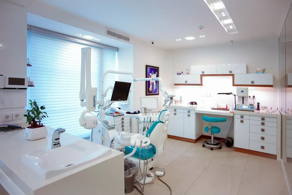 Consultorio odontológico luminoso con sillón, equipamiento y ventana